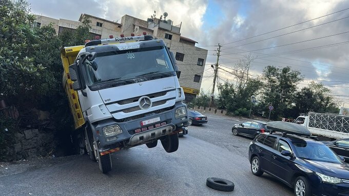 إنزلاق شاحنة الى جانب طريق عاريا صعودًا وحركة المرور طبيعية في المكان